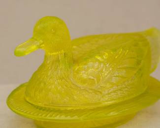 Closeup of vintage Westmoreland uranium vaseline glass duck on nest covered dish