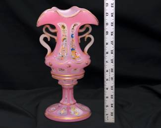 A large Bohemian cut opaque-glass four-handled vase, late 19th century. Likely made for the Persian market. Applied with four loop handles, the opaque glass with pink stain; enameled and gilt with flowers, scrolls, buildings and trailing fruiting vines.