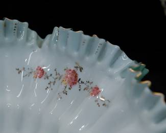 Closeup of 19th century ruffled art glass bowl bride's basket with silver plated basket handle stand