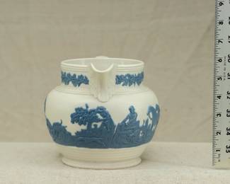 Another view of the antique circa 1810 Chetham and Woolley Hunt Jug, feldspathic stoneware cream color body with applied blue relief of a fox hunting scene, smear glazed. Chetham & Woolley was an earthenware manufactory in Staffordshire, England established by James Chetham & Richard Woolley around 1795.