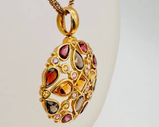 Closeup of 14k yellow gold triple strand necklace with citrine and other fine gemstones pendant