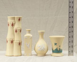 A Wedgwood primrose yellow jasperware bamboo vase, two Wedgwood primrose yellow jasper ware bud vases, and a Wedgwood primrose yellow jasperware vase with applied dark green sprig decoration of a cricket resting on grass blades beneath a flying butterfly 