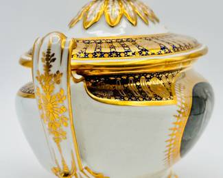 Another view of the rare Worcester Porcelain (Flight) lidded sauce tureen with underplate from the ‘Hope service’ circa 1792, signed with blue crowned script Flight and open crescent marks, painted by John Pennington. The celebrated 'Hope' service was commissioned by the Duke of Clarence and St Andrews (later King William IV), in January 1790, and was completed just over a year later. The Neo-Classical service consists of a soft-paste porcelain base, with a bold blue underglaze lobed border, with gilt patterae, and gilt arched panels and stars. The centre cartouche artwork features the Greek mythological Hope, painted in monochrome using the French-inspired grisaille style. Across the set, Hope is depicted in a variety of poses with an anchor, and often with a ship in the distance.