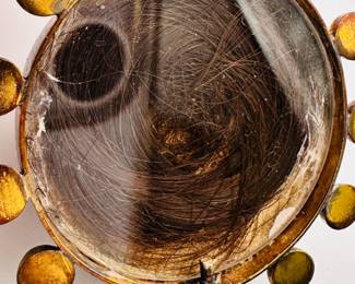 Closeup of the back of one of the banded agate pendants showing a lock of human hair preserved under glass, this piece a part of the group of vintage and antique banded agate jewelry – beaded necklaces, cabochon set link bracelets, dangle earrings, and pendants, including a mourning pendant 