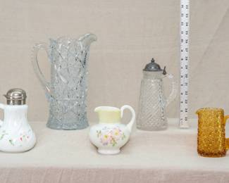Antique American Glass Syrup Pitchers, Water Pitcher, and Cream Pitchers including an Imperial Glass Co. "Nucut" clear crystal pitcher w/hobstars and  sawtooth edge, a Consolidated Glass Co., Coreopsis pattern milk glass creamer circa 1894-1915,  an antique EAPG zippered swirl and diamond pattern tall syrup pitcher with attached metal lid; and a Hobbs & Brockunier amber glass Daisy and Button mini pitcher
