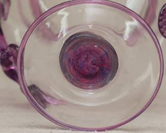 Closeup of Steuben Glass vase, colorless with applied amethyst glass handles and band of amethyst glass at collar, rim and foot rim