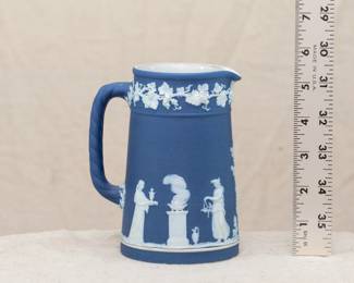 A charming Wedgewood dark blue dip jasperware small 5-1/2 inch pitcher with rope handle, decorated with classical figures in a "sacrifice" scene, beneath a band of fruiting grape vines
