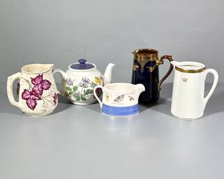 (5pc) Small Pitchers | Including one Sadler England tea pot, white and purple leaf with gold trim pitcher, dark blue and gold made in England and numbered pitcher, shorter Wedgewood “Sarah’s Garden” pitcher and white with gold trim pitcher made in PA.
Dimensions: h. 7 x w. 5.5 in (dark blue)