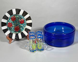 (6pc) Painted Glass Pieces And Bowl | Low glass blue bowl, hand painted plate and four cordial shot glasses.
Dimensions: h. 3.5 x dia. 8 in (Blue bowl)