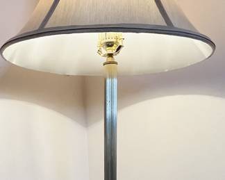 Vintage floor lamp with a brass finish and ornate base.
