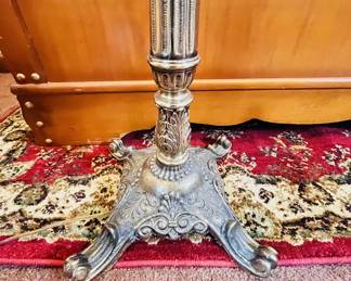 Vintage floor lamp with a brass finish and ornate base.