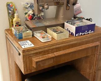 Vintage Singer sewing machine. Sewing cabinet w/bench. Sewing notions. Sold separately.