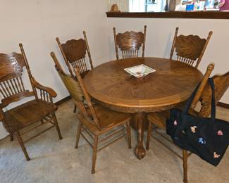 $400 - Round, oak claw pedestal table with 6 carved chairs and one leaf.
