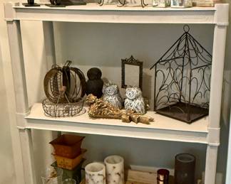 A Shelf full of unique Home Decor and Candles.