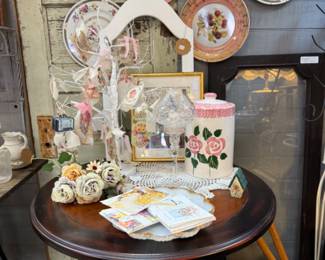 Beautiful plates, feminine touches, vintage end tables and art.