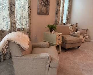 A pair of upholstered, occasional chairs on casters