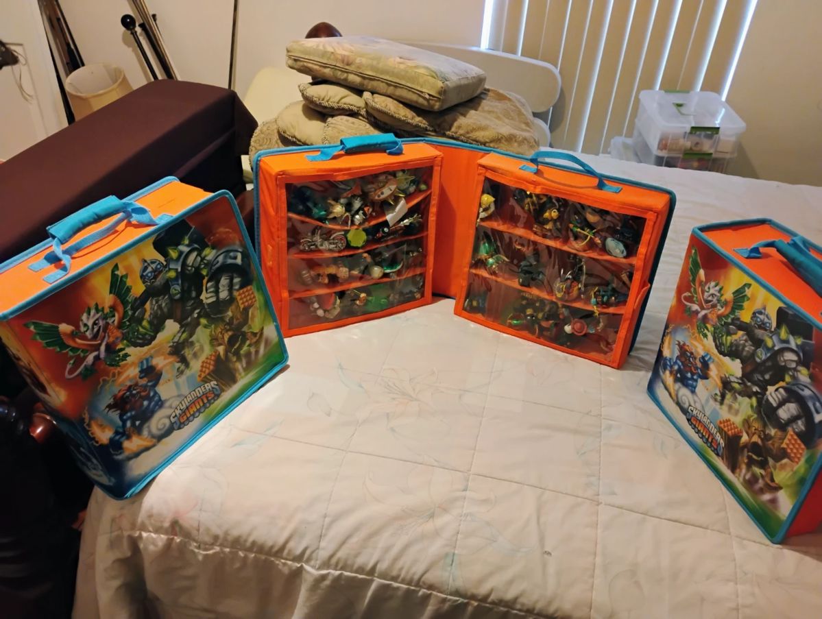 Lots of Skylander action figures in storage boxes