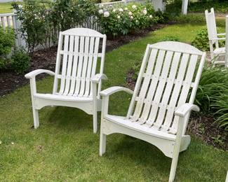 Two white Adirondack outdoor chairs