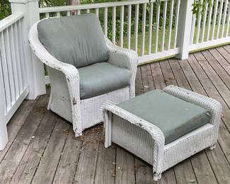 Weather damaged wicker chair with footstool
