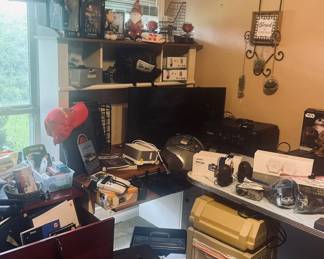 Pop culture items, paper shredder, CD player, dash cam, LUMA, phone set, filing cabinet, Tom Tom, office supplies