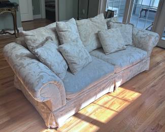 Elegant and comfortable offwhite sofa with cushions and throw pillows