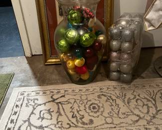 Huge glass vase with ornaments inside 
and package of silver ornaments in plastic  container