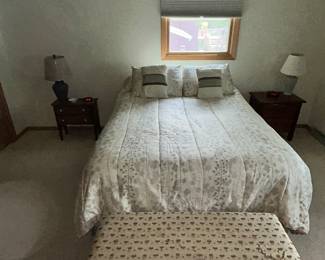 a bed with two side tables and cedar chest.