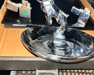 Mac truck hood ornament. From the hood to an ashtray. Two Zippo lighters - one on the left is a vintage Burlington Northern lighter and on the right is a Safway lighter.
