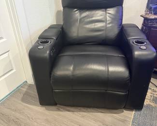#56 - $400 - Black leather theater recliner with all kind of gadgets & lights effect. Client kept the protective cover on. (approx 2 years old) Mint condition