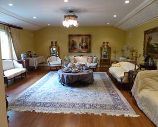 Beautiful living room sofas, chandelier, pair of antique hand painted vitrines, bric-a-brac, framed art, area rug