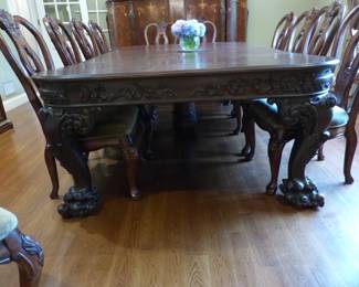 Large ornate antique dining table with 12 chairs