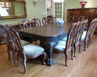 Large ornate antique dining table with 12 chairs