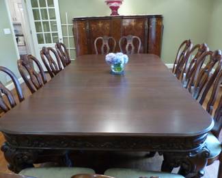 Large ornate antique dining table with 12 chairs
