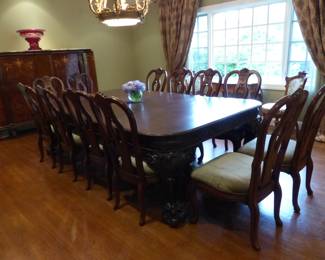 Large ornate antique dining table with 12 chairs