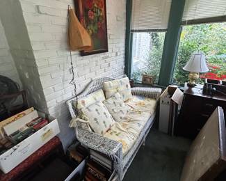 COllection of small frames, wicker sofa, matching rocker, 2 arm chairs, and other wicker tables around the home
