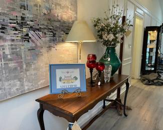 The entrance hall, sofa table/entrance table, large pottery with metal details vase with floral, glass, and art glass lamp, large oil