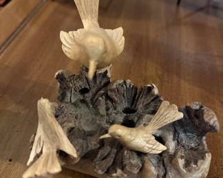 hand carved bird figurines on a piece of Burlwood
