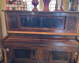 Antique player piano with 26 rolls.
