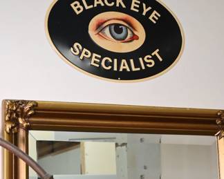 A contemporary but highly stylized "Black Eye Specialist" sign featuring a Victorian-style anatomical eye with bruising and bloodshot detailing.