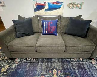 Nearly new grey fabric couch with attached back pillow and flappable seat cushions. 