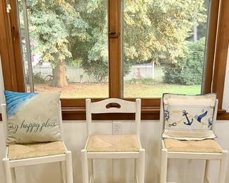 Set of 3 white wooden counter stools with solid rattan seats...pillows not included.