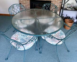 Wrought iron and glass table and four matching chairs. Never outside. Pads match 4 rattan chairs.