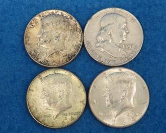 Lot 25. Four silver half dollars. Three 1964 Kennedys and a 1957 Franklin.