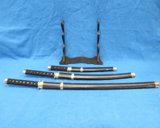 Lot 32. Three-sword set with scabbards and display stand