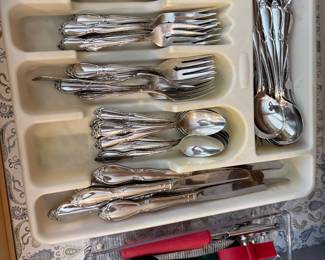 Several sets of silverware, including gold tone.