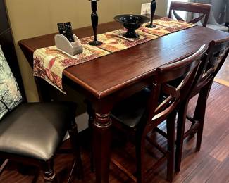 Tall table with one extra hidden leaf for expansion if needed. Four matching bar stools with leather seats also available. Accommodates 6 - with leaf will seat 8