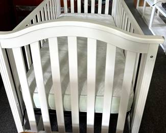 White infant crib with adjustable height. - mattress has side tear, but is available for free with crib purchase