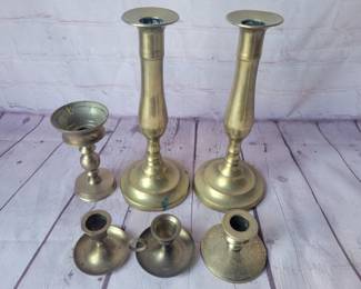 Lot of brass candleholders with round bases.