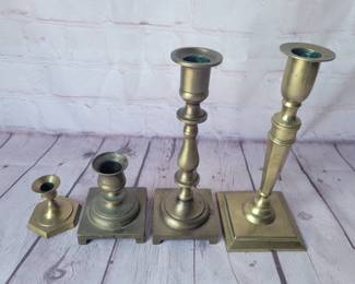 Lot of brass candleholders with square bases.