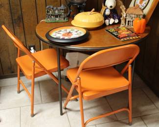 orange folding chairs and round table